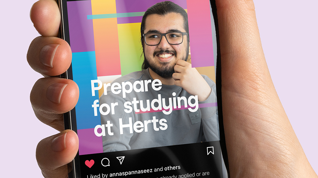hand holding an iPhone, displaying a social media post by the university of hertfordshire